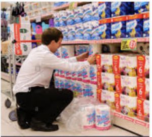 person crouched down, stocking a store shelf